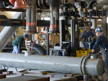 Men servicing plumbing equipment